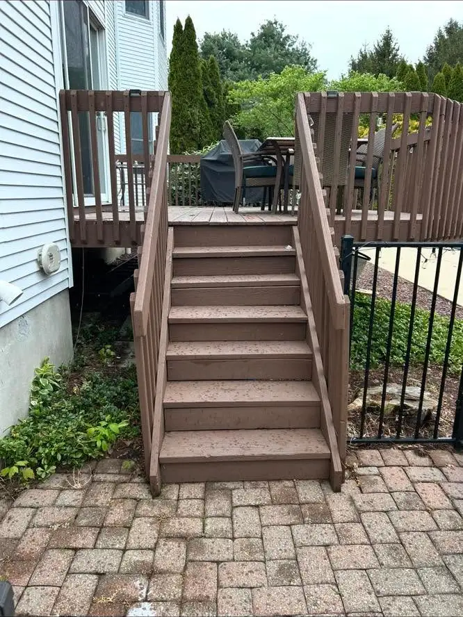 The same deck stairs before replacement, worn and weathered brown.